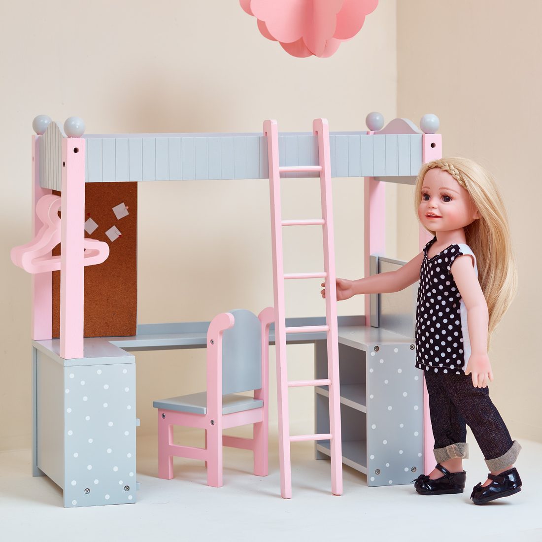 18-inch doll beside a wooden loft bed and desk